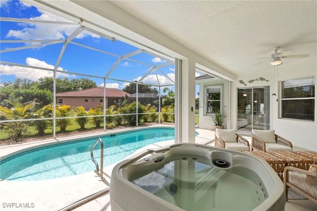 outdoor pool featuring glass enclosure, a patio, a jacuzzi, and a ceiling fan