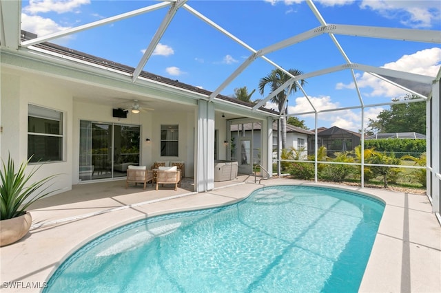 pool featuring a patio area, glass enclosure, and ceiling fan