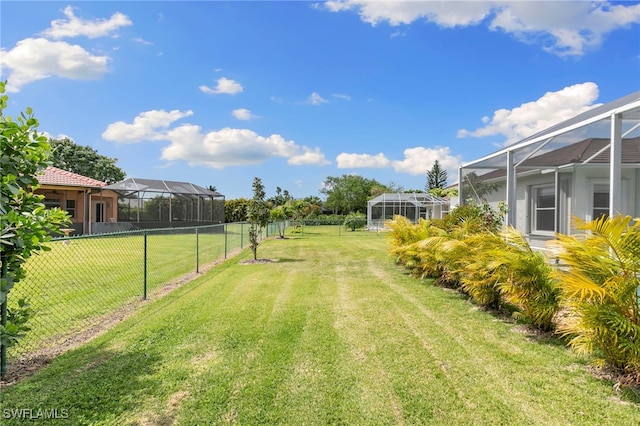 view of yard featuring glass enclosure and a fenced backyard