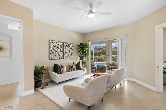 living room with light tile patterned floors, baseboards, and a ceiling fan