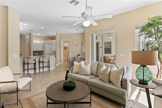 living room with baseboards, recessed lighting, visible vents, and ceiling fan