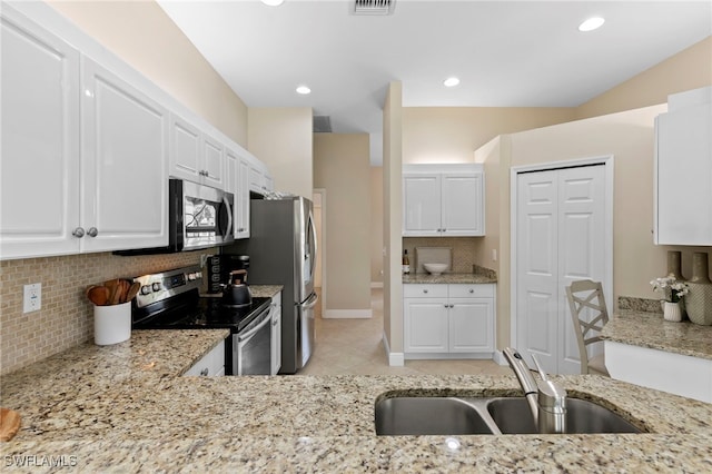 kitchen featuring a sink, stainless steel appliances, light stone countertops, and backsplash