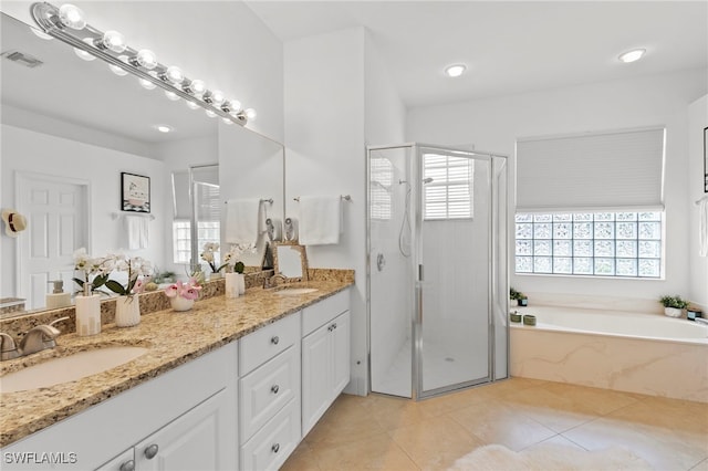 full bath with visible vents, a garden tub, a stall shower, a sink, and double vanity