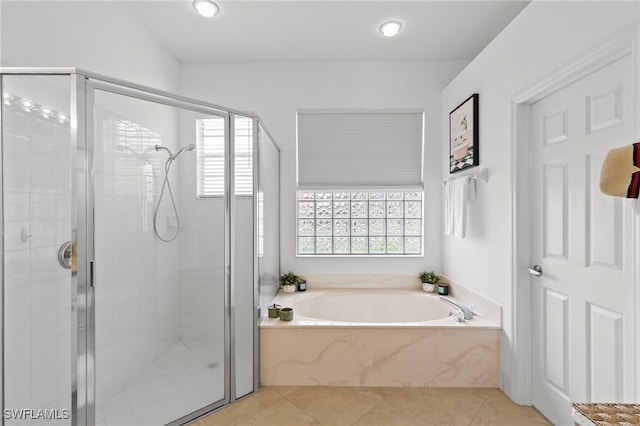 bathroom with tile patterned floors, a bath, and a shower stall