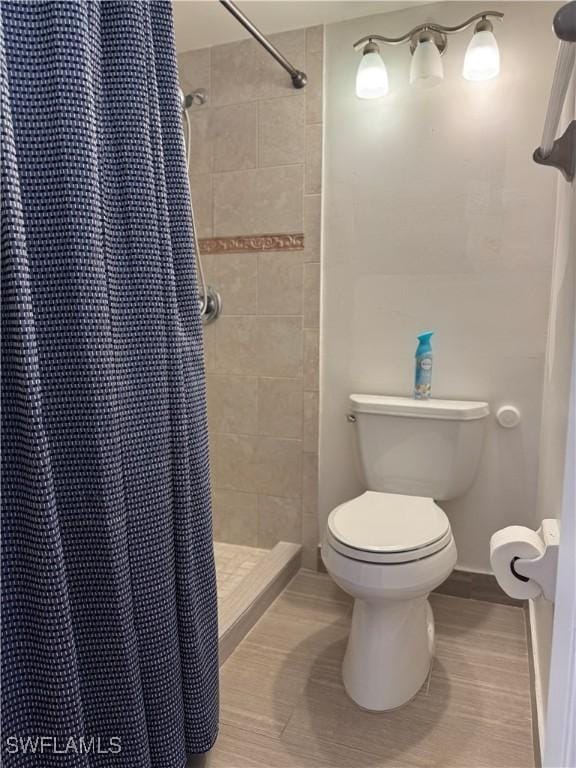 full bathroom featuring toilet and a stall shower