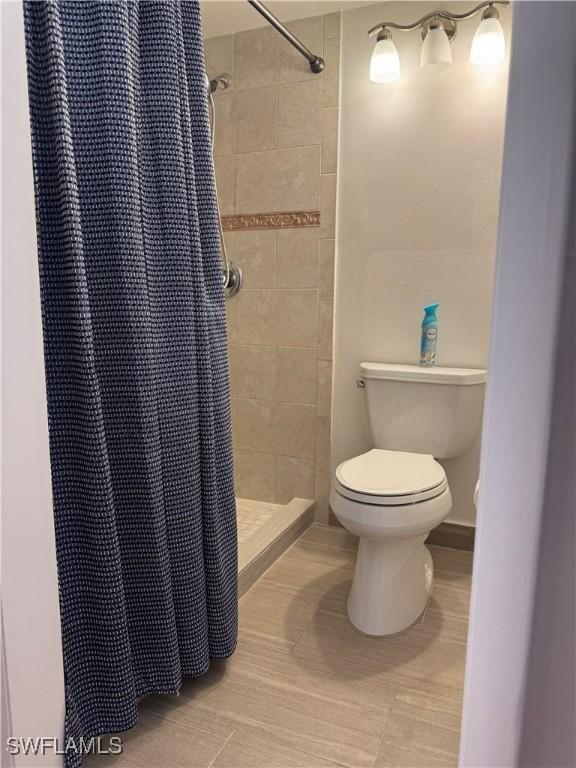 bathroom with toilet and a shower stall