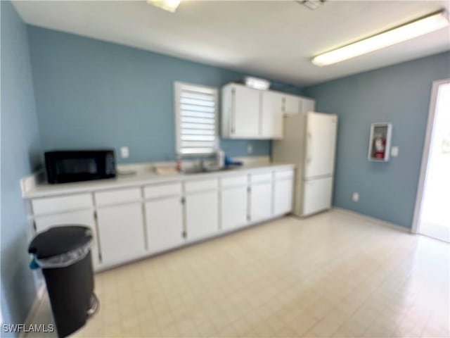 kitchen featuring white cabinetry, a healthy amount of sunlight, and white refrigerator