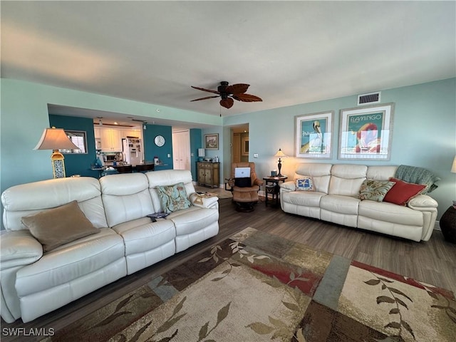 living room with dark wood-type flooring and ceiling fan