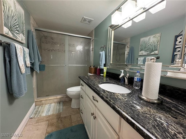 bathroom featuring vanity, a shower with door, and toilet