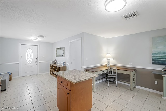 kitchen featuring light tile patterned flooring and a textured ceiling