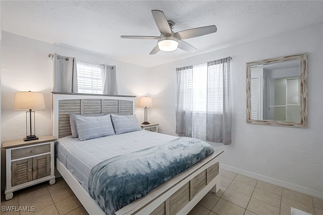 bedroom featuring light tile patterned flooring, ceiling fan, and a textured ceiling