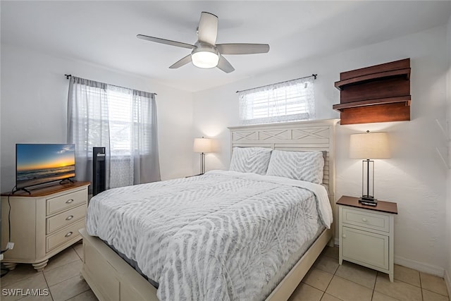 tiled bedroom featuring ceiling fan and multiple windows