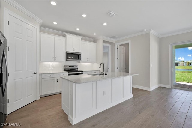 kitchen featuring sink, white cabinetry, a center island with sink, light wood-type flooring, and stainless steel appliances