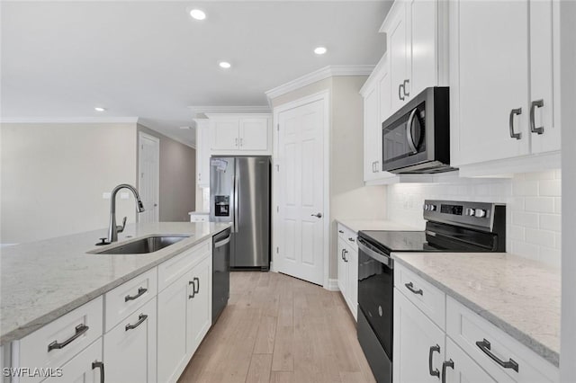 kitchen featuring sink, light stone counters, crown molding, stainless steel appliances, and white cabinets