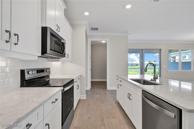 kitchen featuring sink, crown molding, white cabinetry, stainless steel appliances, and light stone countertops