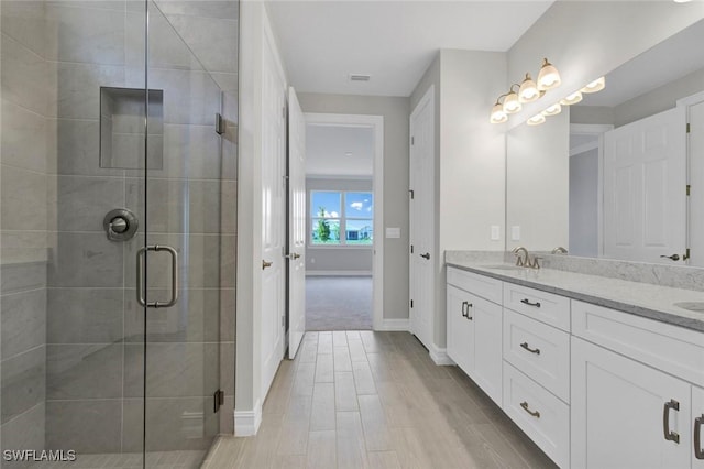 bathroom with vanity, wood-type flooring, and an enclosed shower