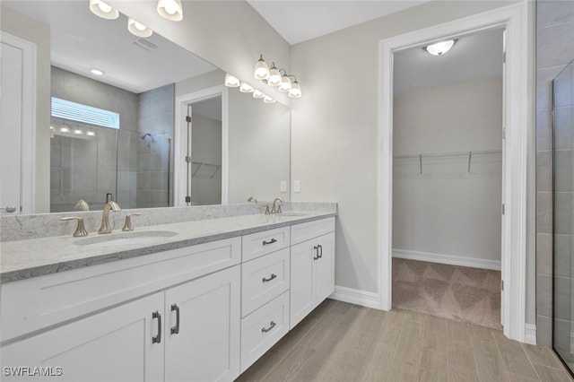 bathroom featuring vanity, hardwood / wood-style flooring, and a shower with door