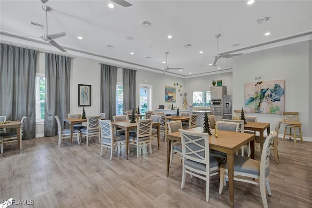 dining room featuring crown molding, ceiling fan, and light hardwood / wood-style flooring