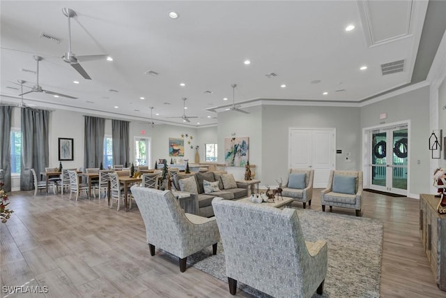 living room featuring crown molding, ceiling fan, and light wood-type flooring