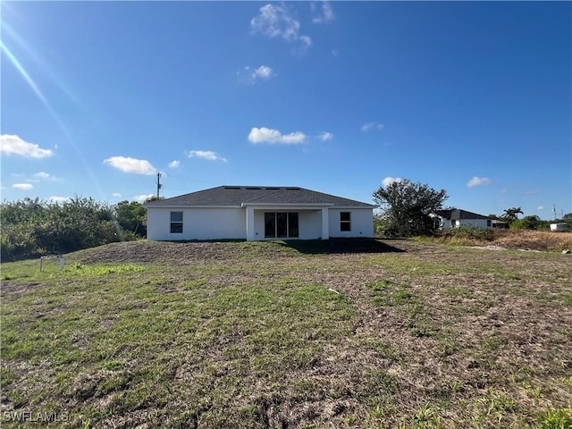 rear view of property with a lawn