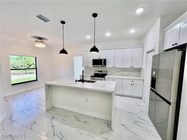 kitchen featuring stainless steel appliances, white cabinetry, sink, and a kitchen island with sink