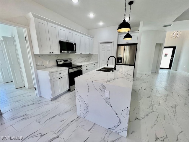 kitchen featuring white cabinetry, stainless steel appliances, sink, and hanging light fixtures