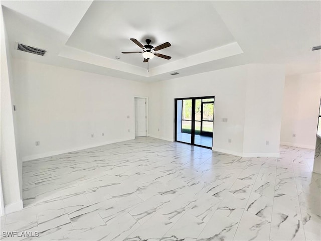 spare room with french doors, ceiling fan, and a tray ceiling