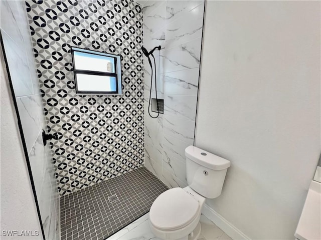 bathroom featuring toilet and a tile shower