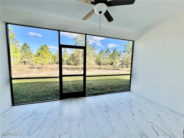 unfurnished sunroom featuring ceiling fan