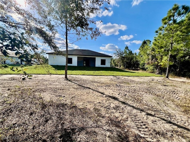 rear view of property featuring a lawn