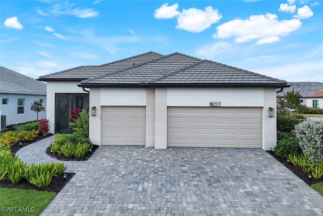 view of front of house featuring a garage and central AC unit