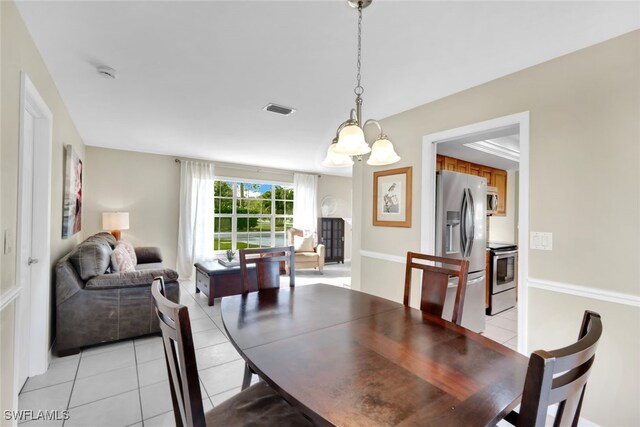 dining space featuring light tile patterned floors and an inviting chandelier