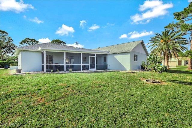 back of house featuring a sunroom and a lawn