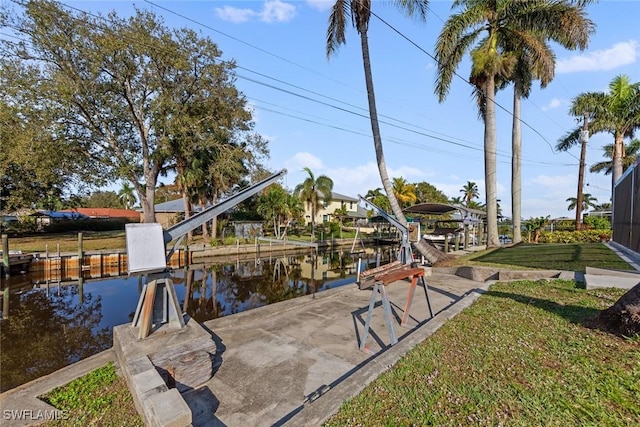 view of dock with a yard and a water view