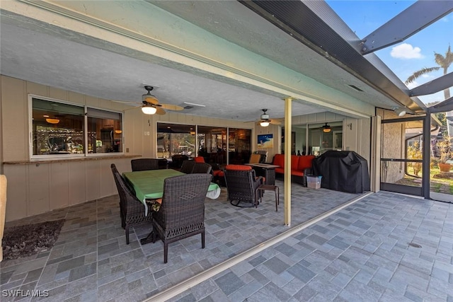 view of patio / terrace featuring ceiling fan, a lanai, an outdoor hangout area, and grilling area