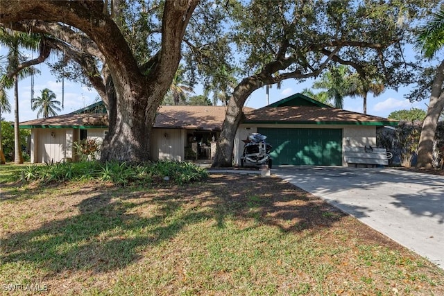 ranch-style home with a garage and a front lawn