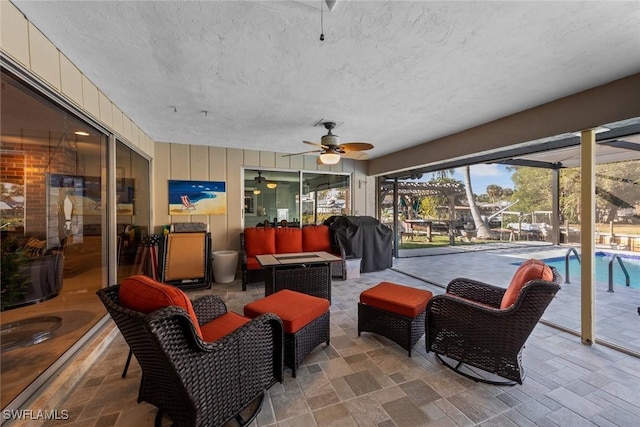 interior space featuring a grill, an outdoor hangout area, ceiling fan, and glass enclosure