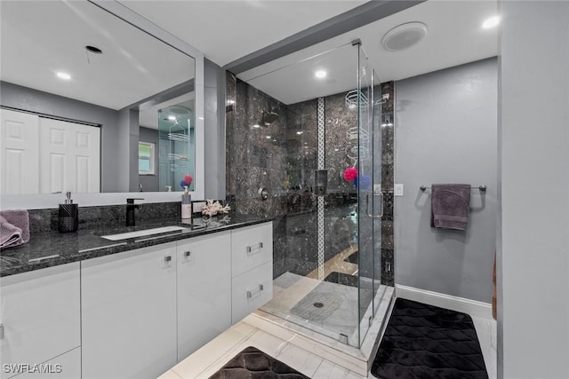 bathroom featuring vanity and a shower with door