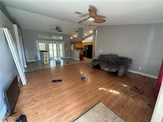 living room with ceiling fan, lofted ceiling, and light wood-type flooring