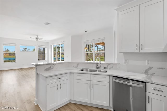 kitchen with sink, white cabinetry, light stone countertops, stainless steel dishwasher, and light wood-type flooring