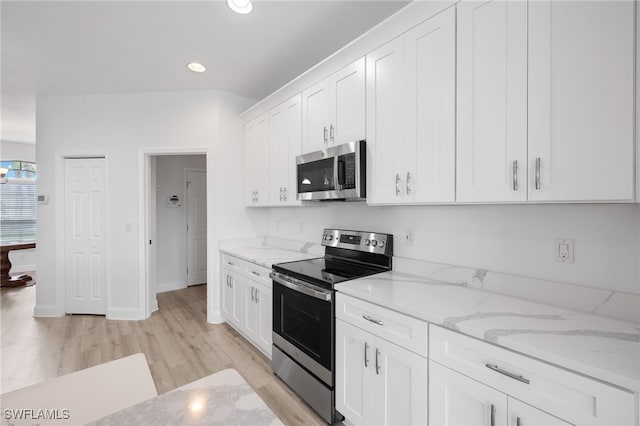 kitchen featuring light stone countertops, appliances with stainless steel finishes, white cabinets, and light hardwood / wood-style floors