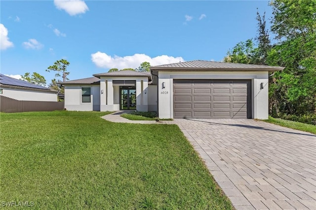 view of front of home featuring a garage and a front lawn