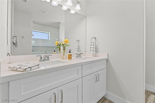 bathroom featuring hardwood / wood-style flooring, vanity, and an enclosed shower