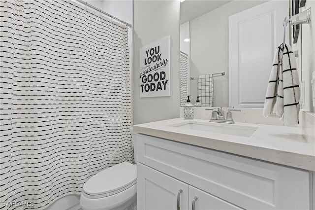 bathroom featuring a shower with curtain, vanity, and toilet