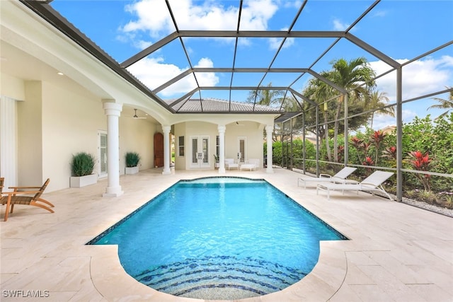 view of swimming pool with french doors, a patio, ceiling fan, and glass enclosure