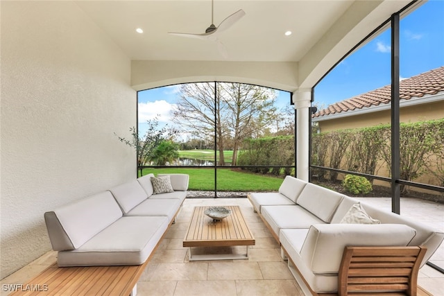 sunroom / solarium with a water view and ceiling fan