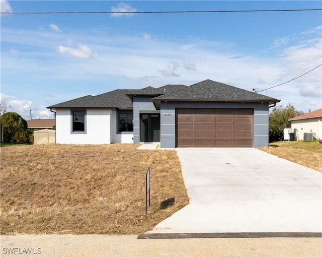 view of front of property featuring a garage, a front yard, and cooling unit