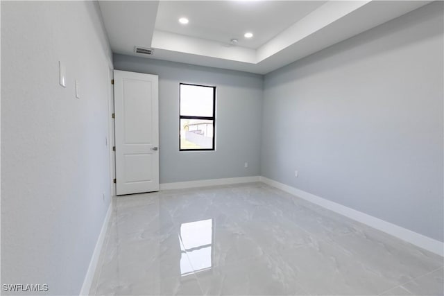 empty room featuring a raised ceiling