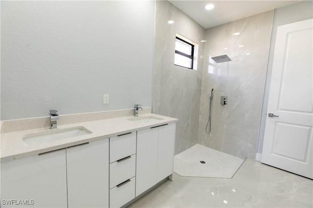 bathroom with tiled shower and vanity