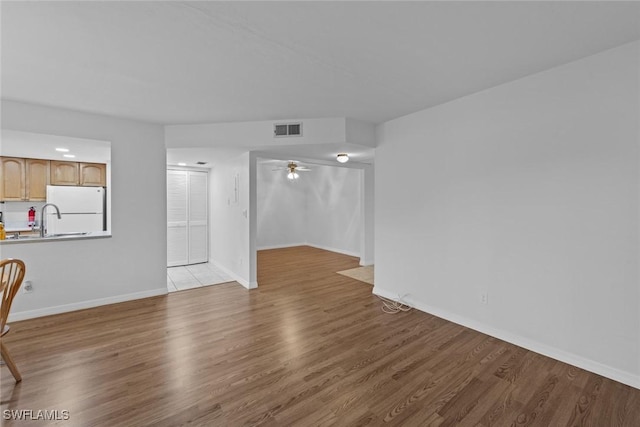 interior space with ceiling fan and light hardwood / wood-style flooring